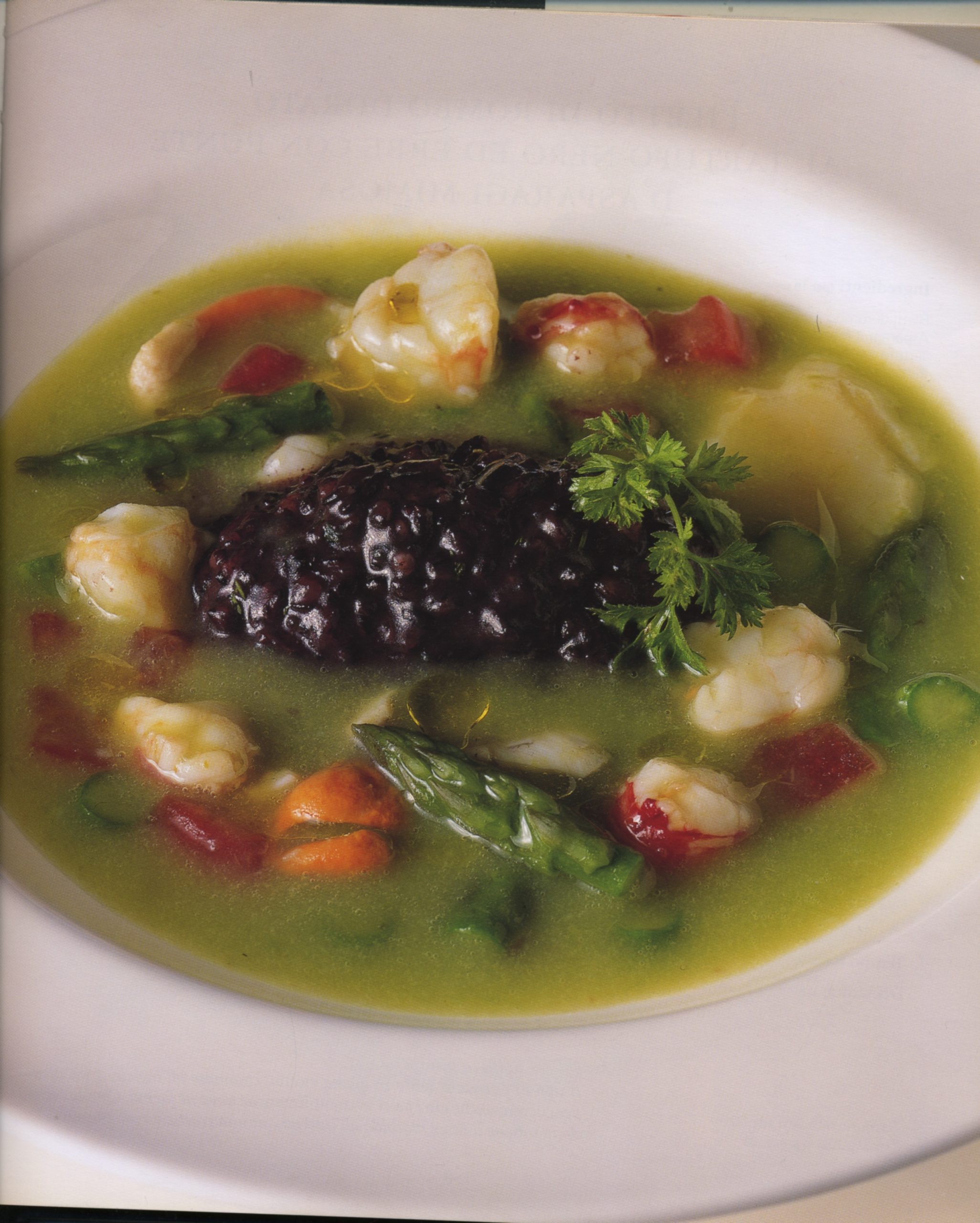 Risotto nero integrale con ragout di capesante, gamberi e asparagi