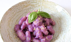 Gnocchi de patata con salsa de col morada, queso provolone y ralladura de limón